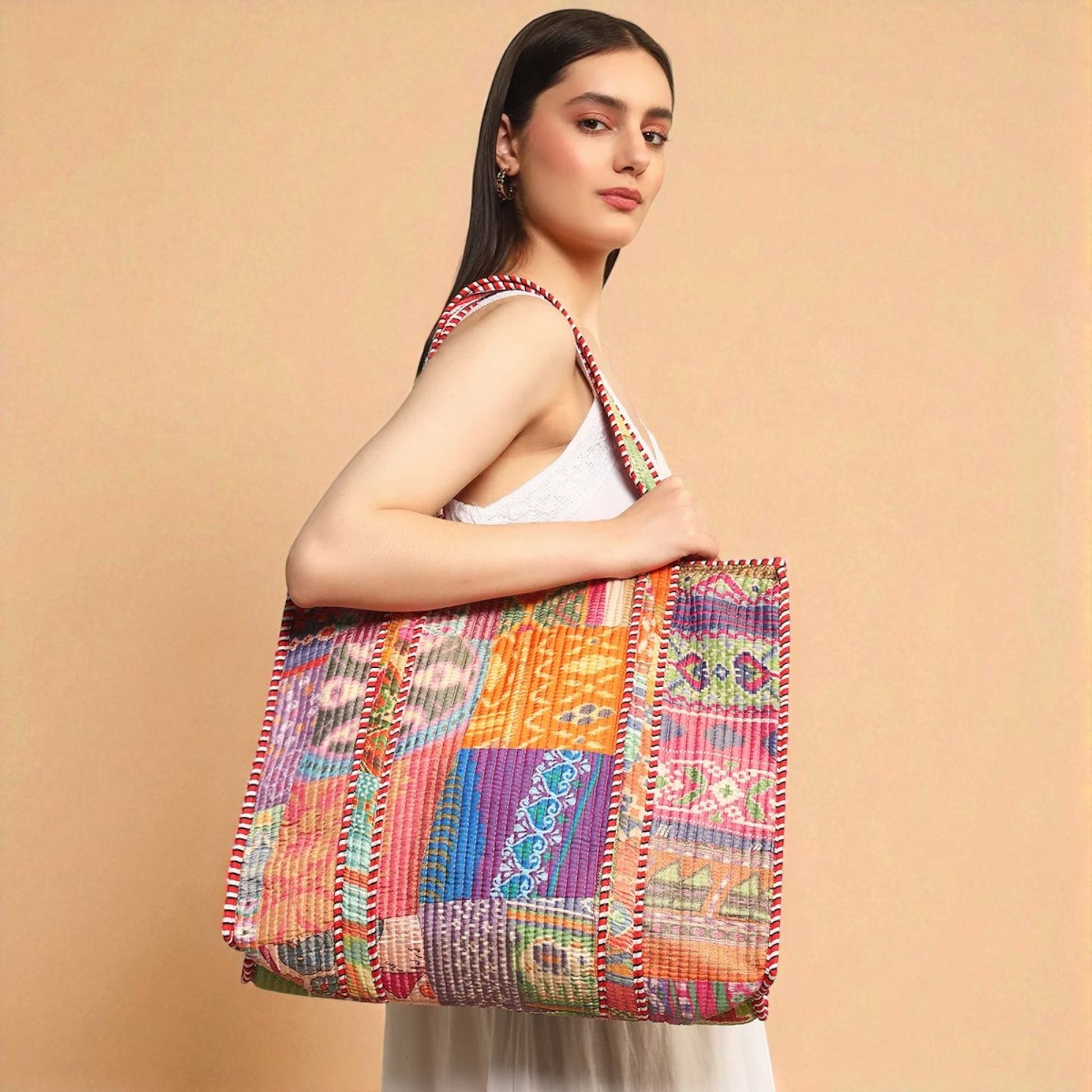 Woman holding a colorful patchwork bag against a beige background